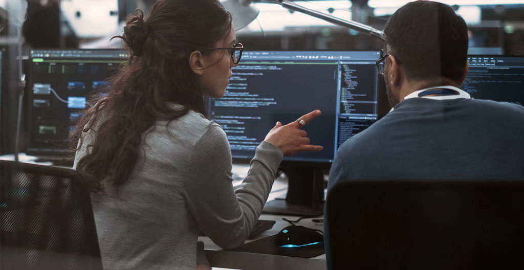 Équipe de spécialistes en cybersécurité analysant un incident sur plusieurs écrans dans une salle de crise moderne